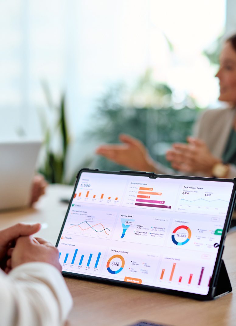 Tablet displaying business charts and analytics during a meeting