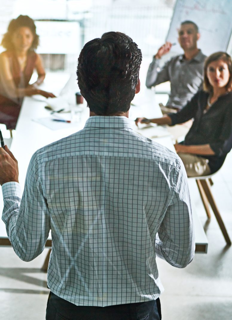 Man giving a presentation to colleagues in a meeting room.